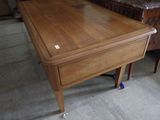 a wooden table with a drawer on it in a room