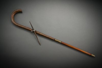 an old cane with a wooden handle sitting on top of a table