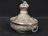 an ornate silver box with a bird on top of it
