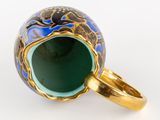 a close up of a blue and gold cup with a ring on it