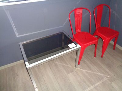 deux chaises rouges et une table en verre dans une pièce