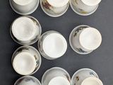 nine cups and saucers arranged in a square on a table