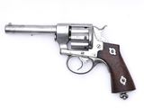 un vieux revolver avec une poignée en bois sur une surface blanche