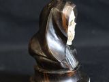 a small statue of a person with a hood on