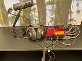 deux microphones posés sur une table, avec un tableau en arrière-plan