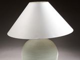 a lamp that is sitting on a table with a white shade on it