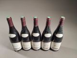 six bottles of wine are lined up on a table
