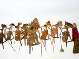 un groupe de figurines en bois posées sur une surface blanche