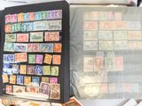 beaucoup de timbres posés sur une table, à côté d'un livre