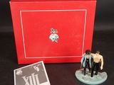 La figurine se trouve dans une boîte rouge sur laquelle est représenté un homme et une femme