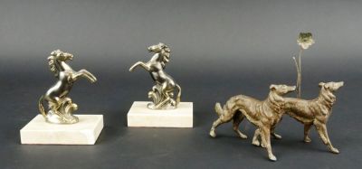 trois figurines en bronze représentant un chien et une femme, posées sur un socle