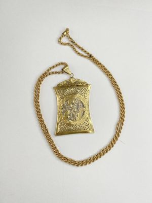 a gold necklace with a small pendant on a gold chain