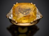 un gros plan sur une bague sertie d'un saphir jaune et de diamants
