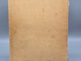 an old book sitting on top of a metal stand