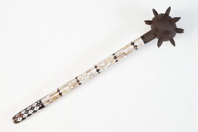 a wooden stick with a flower on it on a white surface