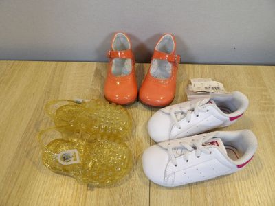 two pairs of shoes and a bag on a table