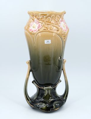 un vase posé sur un support sur une surface blanche