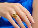woman in a blue dress with a gold ring on her finger