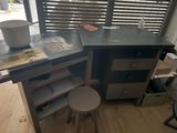 a desk with a chair and a stool in front of a window