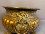 un pot en or orné d'un lion, posé sur une table