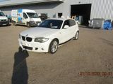 une BMW blanche garée devant un immeuble