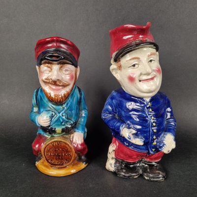 two ceramic figurines of two men with hats and beards