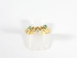 un gros plan d'une bague en or sertie de deux émeraudes