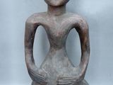 a close up of a statue of a woman sitting on a rock