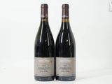 deux bouteilles de vin rouge posées l'une à côté de l'autre sur une surface blanche