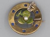 une image représentant une broche en or ornée d'une perle et de saphirs bleus