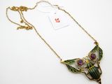 gros plan d'un collier sur une surface blanche avec une étiquette de prix