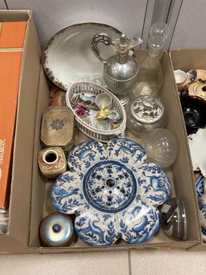 une boîte remplie d'objets hétéroclites posée sur le sol