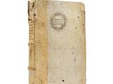 an old book sitting on top of a white table next to a white wall
