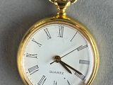 a gold pocket watch with roman numerals on it