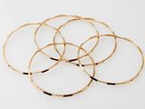 gold plated bang bracelets on a white background