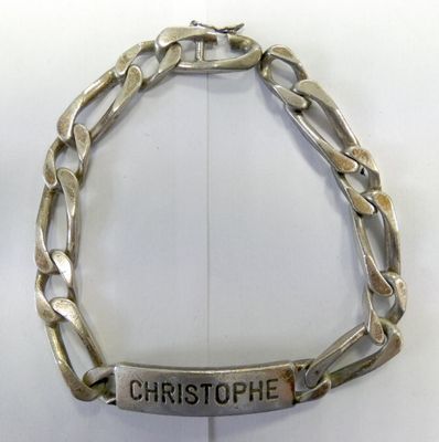 silver plated bracelet with engraved name on it on a white surface
