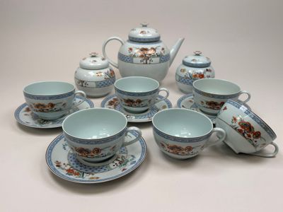 plusieurs tasses et soucoupes et une théière sur la table