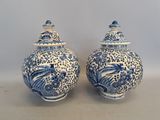two blue and white vases sitting on top of a table