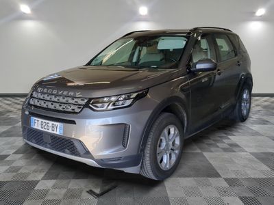 La Land Rover grise est garée dans une grande pièce au sol carrelé en damier.
