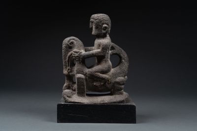 an image of a statue of a woman sitting on a rock
