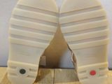a pair of white shoes that are on a wooden floor