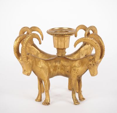 a gold candle holder with a ram on it