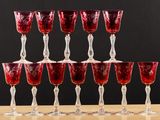 several red wine glasses sitting on top of a wooden table