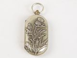 a close up of a silver pendant with a flower on it