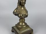 a bronze bust of a woman on a pedestal