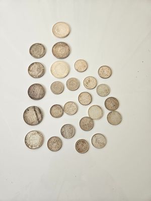 a pile of silver coins sitting on top of a white surface