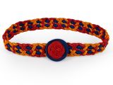 un gros plan d'un bracelet tressé orné d'un bouton rouge et bleu
