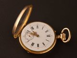 a gold pocket watch with roman numerals on it