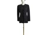 une veste en tweed noir et blanc et un chapeau posés sur un présentoir pour mannequin