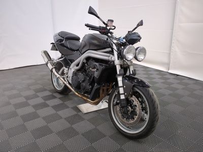 une moto noire garée sur un sol à carreaux noirs et blancs